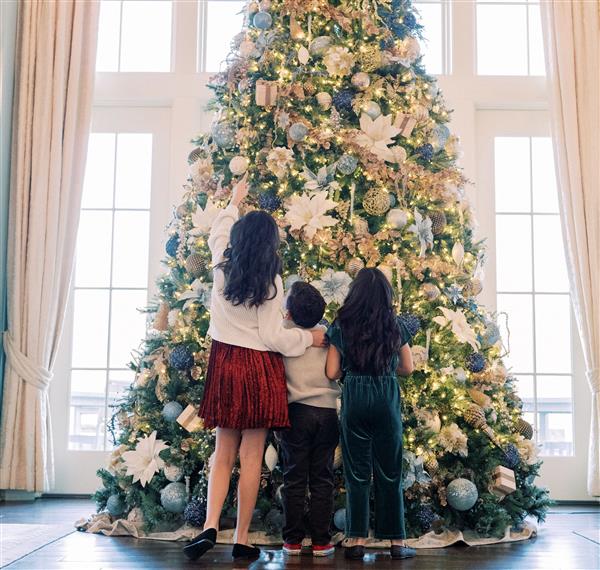 Kids putting ornaments on Christmas tree